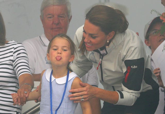 Charlotte sticks her tongue out as Kate encourages her to wave