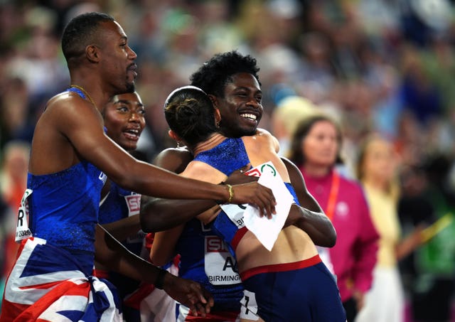 Jeremiah Azu, right, hugs Amy Hunt as they celebrate their relay gold medals