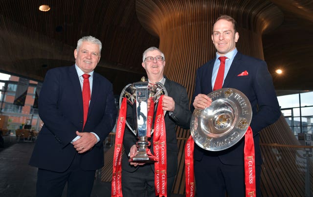 (From left to right) Wales head coach Warren Gatland, First Minister of Wales Mark Drakeford and captain Alun Wyn Jones pose for a photo with the Six Nations trophy and Triple Crown trophy