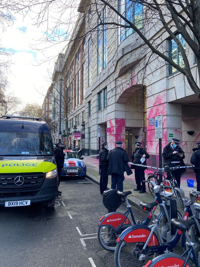 Police outside the Department for Transport, which has been vandalised with pink paint