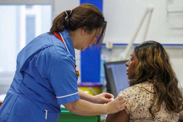A vaccinator administering the flu jab to a person 