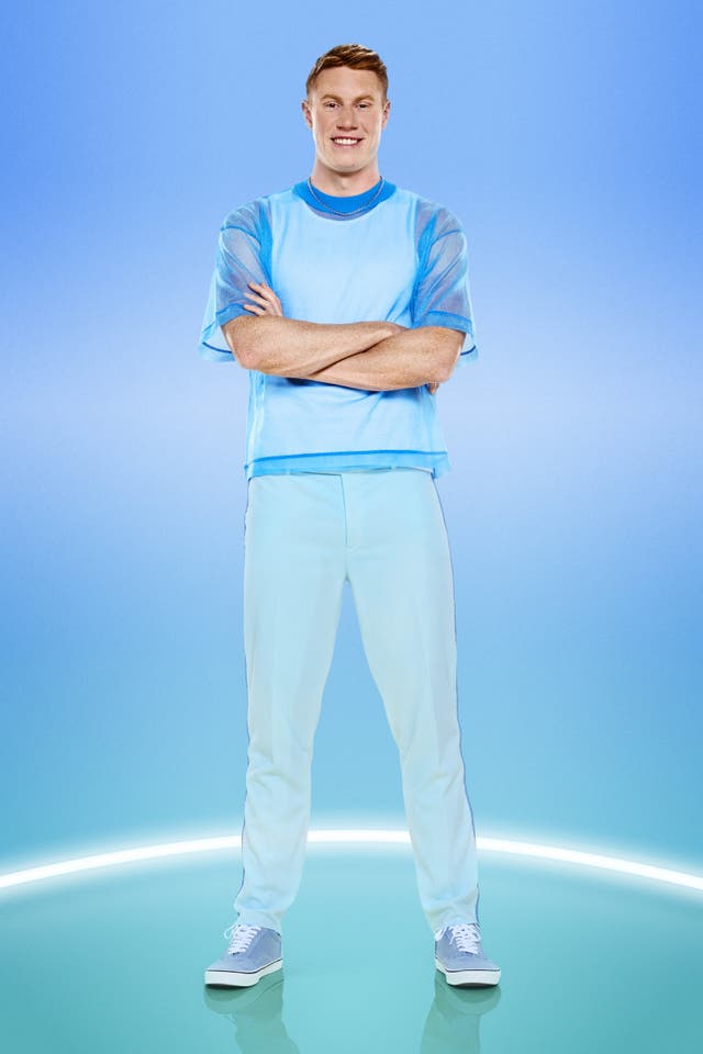 Olympian Tom Dean poses in a blue costume with his arms folded