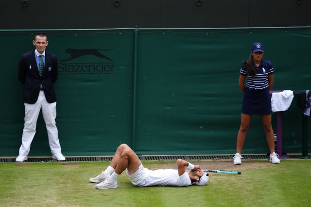 Lorenzo Musetti falls to the floor with his hands over his eyes after reaching the Wimbledon quarter-finals