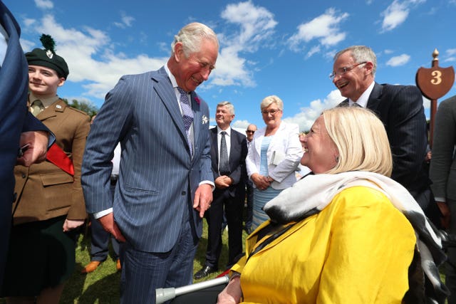 The Prince of Wales greets guest Penny Redman at the Castle Coole garden party