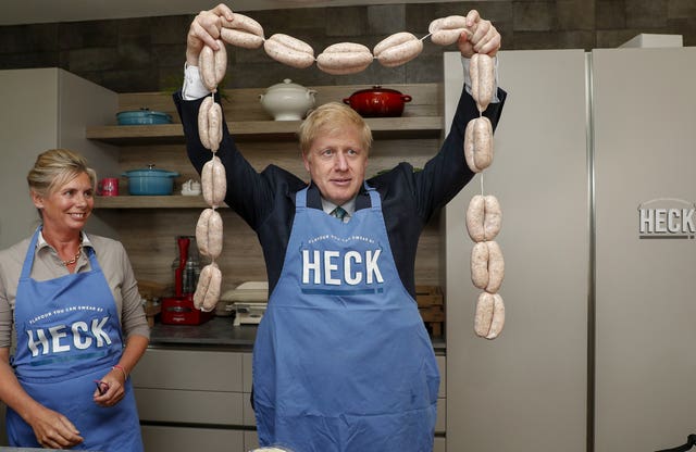 Conservative Party leadership candidate Boris Johnson holds up a string of sausages