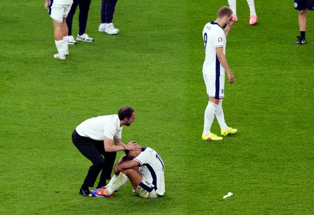 Gareth Southgate consoles Jude Bellingham who sits on the pitch after the Euro final defeat