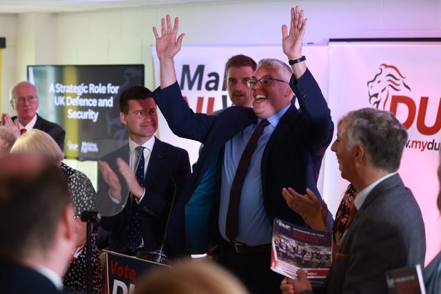 DUP leader Gavin Robinson raises his hands in the air after speaking at the party's manifesto launch