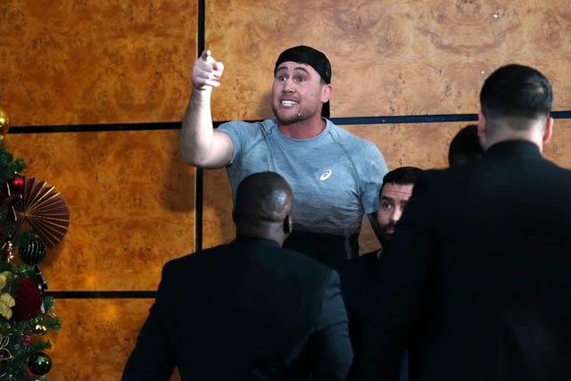 Darren Till reacts with finger raised and surrounded by security after John Fury (not pictured) appears to throw a bottle of water towards him during a press conference