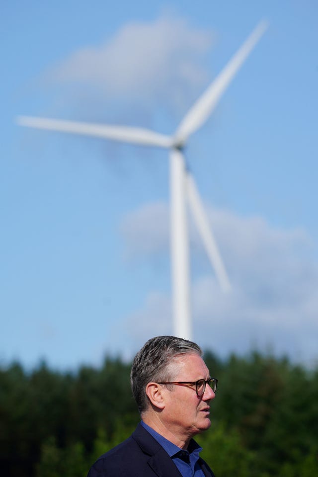 Sir Keir Starmer in the foreground with a wind turbine visible behind him