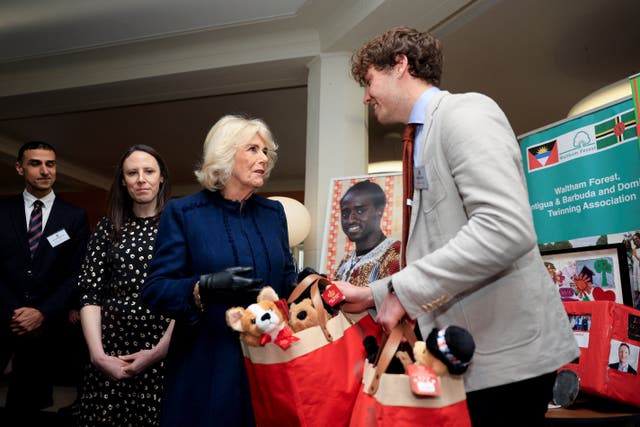 The Queen gives a young man two bags of toys