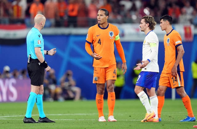 English referee Anthony Taylor speaks to Dutch and French players during a VAR check in the Euro 2024 group match