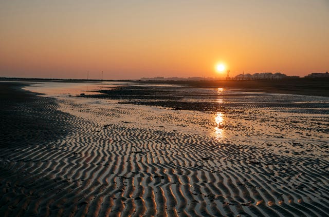 The sun rises over Juno beach near Graye-sur-Mer in France