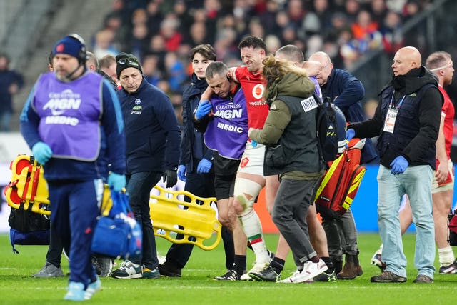 Wales’ Owen Watkin is helped off the pitch after suffering a knee injury