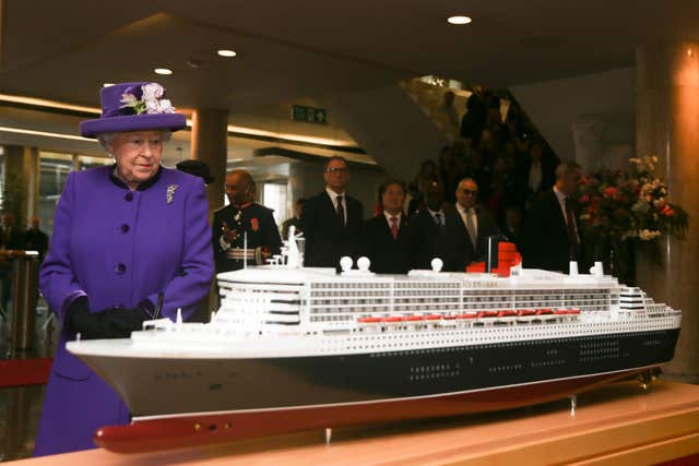 The Queen is shown a model of the RMS Queen Mary 2 transatlantic ocean liner (Daniel Leal-Olivas/PA)