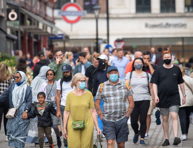People wearing face masks among crowds of pedestrians in Covent Garden, London (Dominic Lipinski/PA)
