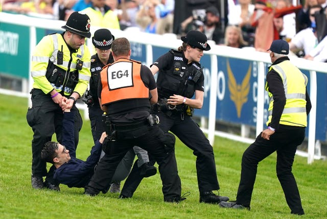 A protester is arrested at Epsom 