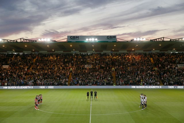 Lincoln and Derby players gather round the centre circle for a minute's silence