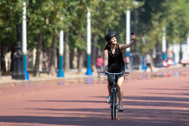 A cyclist takes a selfie on the Mall in central London on August 9 