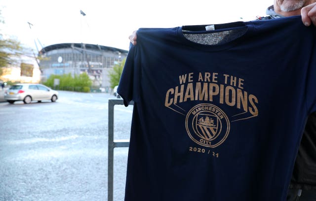 A Manchester City fan holds up a ‘We Are Champions t-shirt’ at the Etihad Stadium