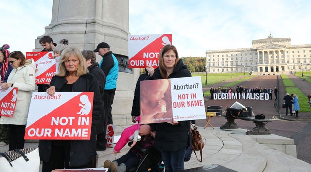 Anti-abortione and pro choice activists take part in a photocall in the grounds of Stormont (Niall Carson/PA)
