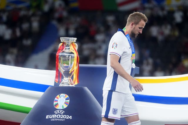 Harry Kane walks past the Henri Delaunay Cup 