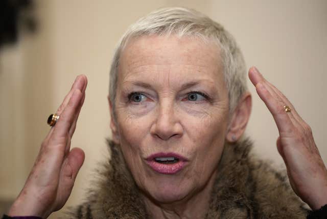 Annie Lennox raises her hands to her head