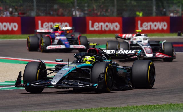 Lewis Hamilton drives his Mercedes around the track as he is chased by two cars