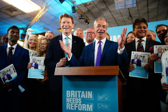 Nigel Farage behind a podium backed by Reform UK chairman Richard Tice amd party supporters
