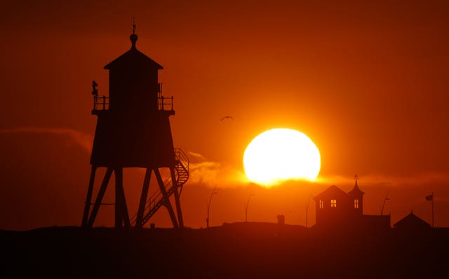 The sun rises over the Groyne lighthouse in South Shields, Tyne and Wear