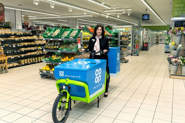 Jo Whitfield, CEO Co-op Retail, with one of the home delivery bikes at the Coop Chelsea store, London