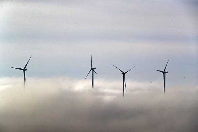 Wind turbines are seen peaking out of the top of low lying clouds over Lancashire.
