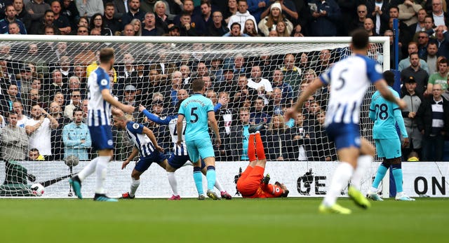 Neal Maupay, centre left, wheels away after scoring as Hugo Lloris, centre right, lies injured