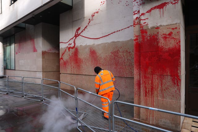 A worker cleans red paint from the walls of the BBC's building in Portland Place, London