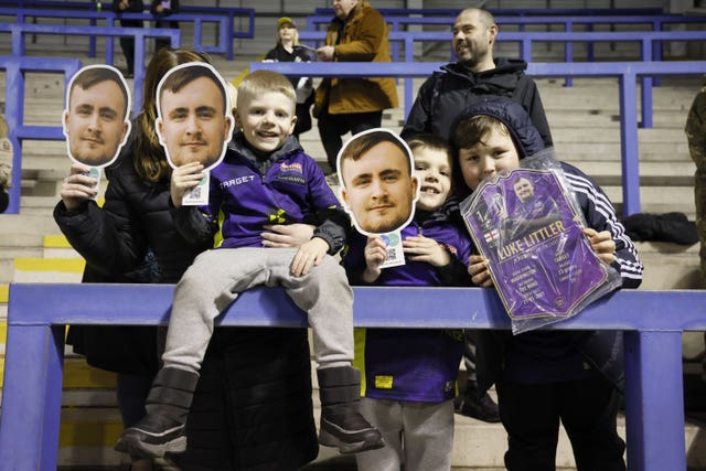 Young fans wearing Luke Littler masks