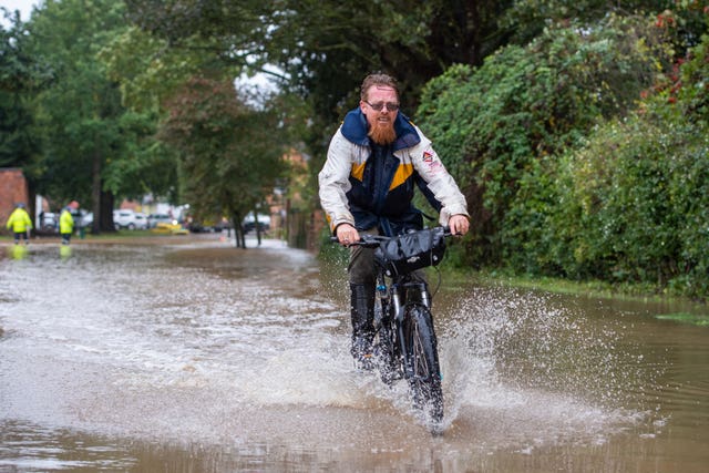 A man cycles through floodwater in Cossington, Leiceste