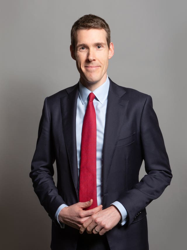 Matthew Pennycook smiling, posing for formal Parliament portrait