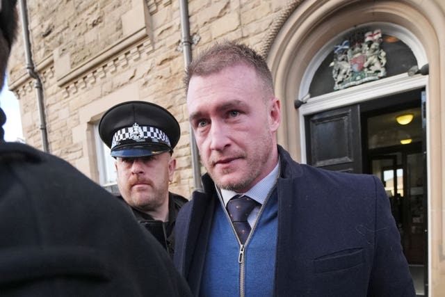 Stuart Hogg alongside a policeman outside court building