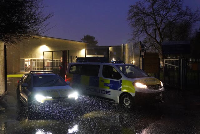 Two police vehicles outside the gates at Kingsbury High School