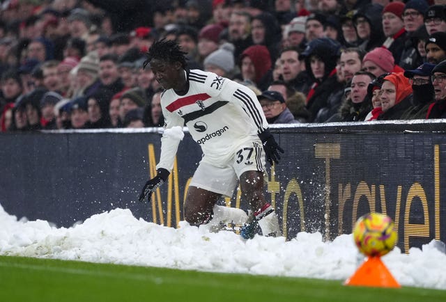 Kobbie Mainoo slides into a bank of snow