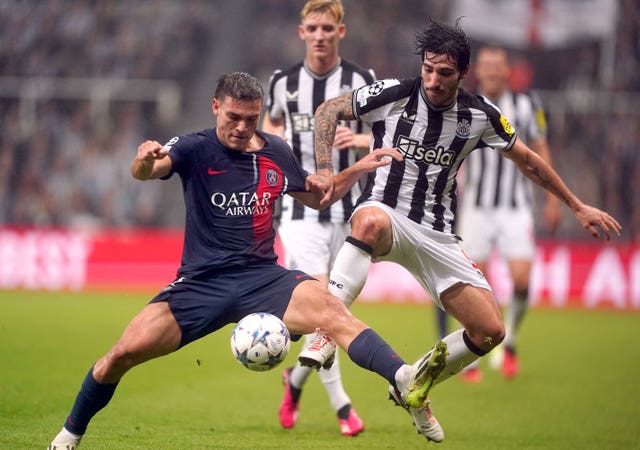 Manuel Ugarte battles for the ball with Sandro Tonali as Anthony Gordon watches on