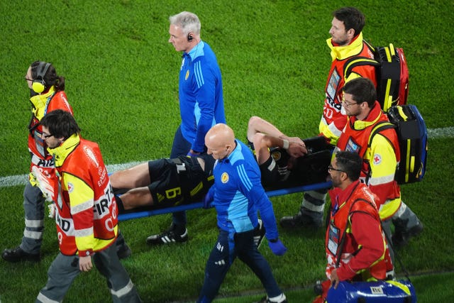 Kieran Tierney holds his head in his hands as he is carried off the pitch on a stretcher