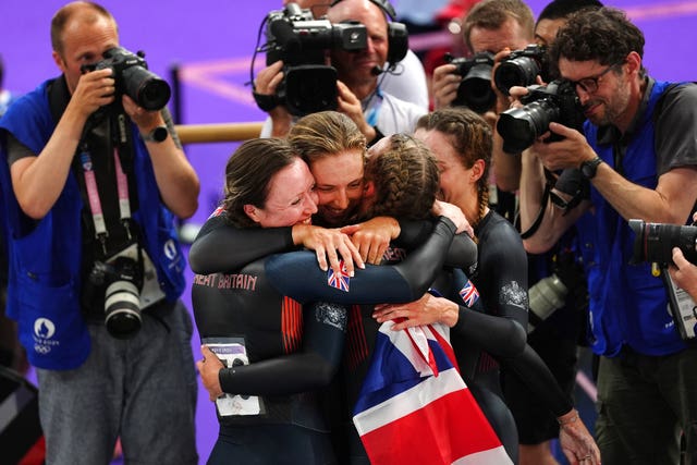 Elinor Barker, Josie Knight, Anna Morris and Jessica Roberts hug each other after winning bronze, surrounded by photographers. 