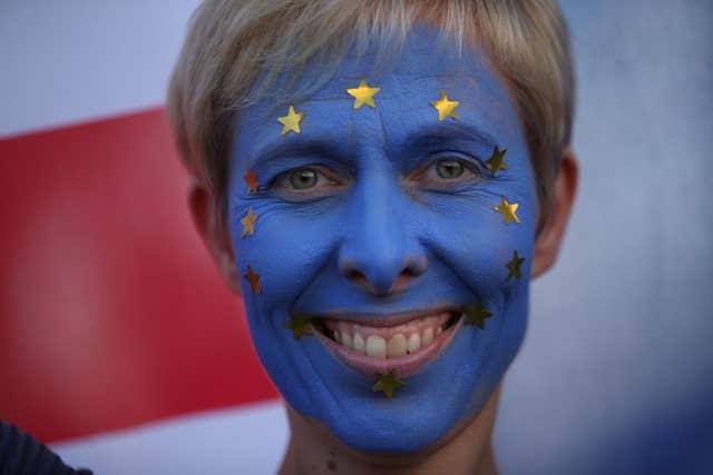 An anti-Brexit campaigner with her face painted in the colours of the European Union flag 