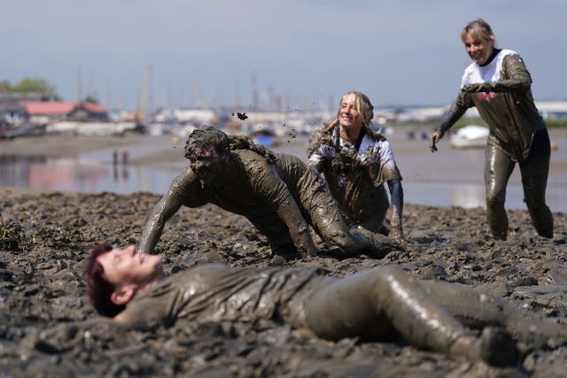Competitors take part in the annual Maldon Mud Race, a charity event to race across the bed of the River Blackwater in Maldon, Essex