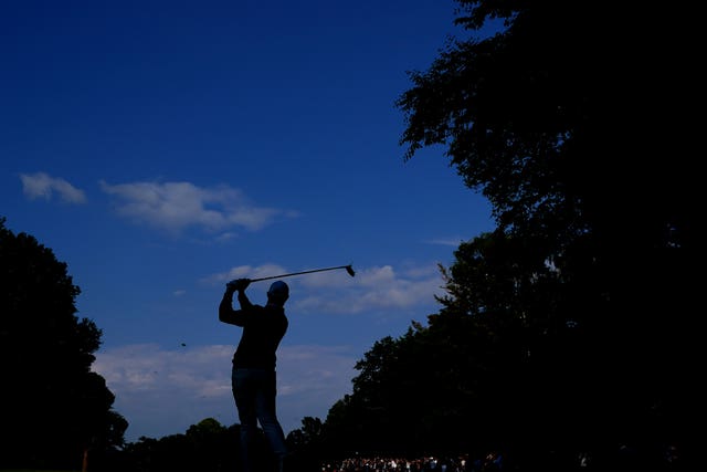 Silhouette image of Rory McIlroy hitting an iron shot