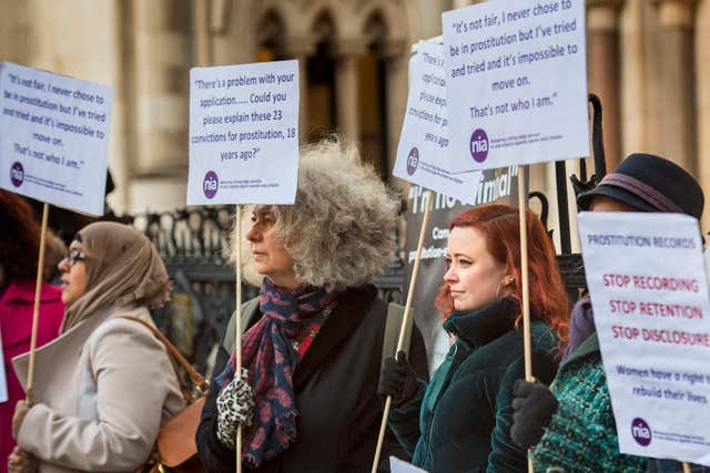 Women take part in a demonstration outside the High Court in London before a case brought by former sex workers against the government (Victoria Jones/PA)