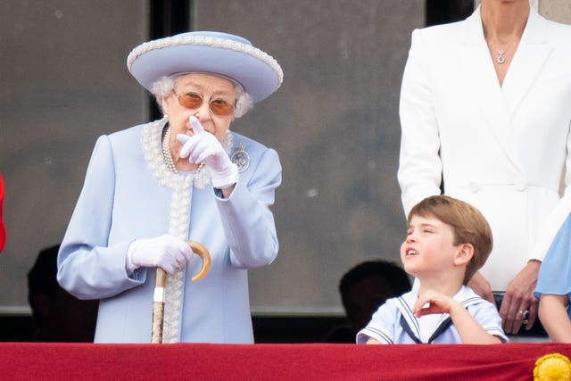 The Queen speaks to Prince Louis on the balcony of Buckingham Palace as they watch the Platinum Jubilee fly-past on day one of the Platinum Jubilee celebrations