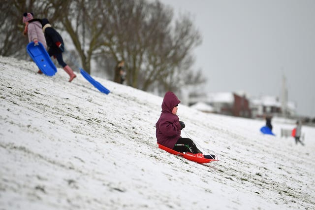 A child goes sledging in the snow