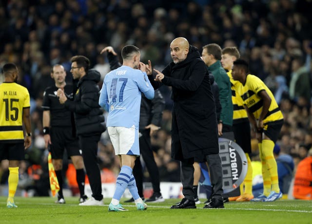 Pep Guardiola, right, speaks to Phil Foden on the pitch at full-time