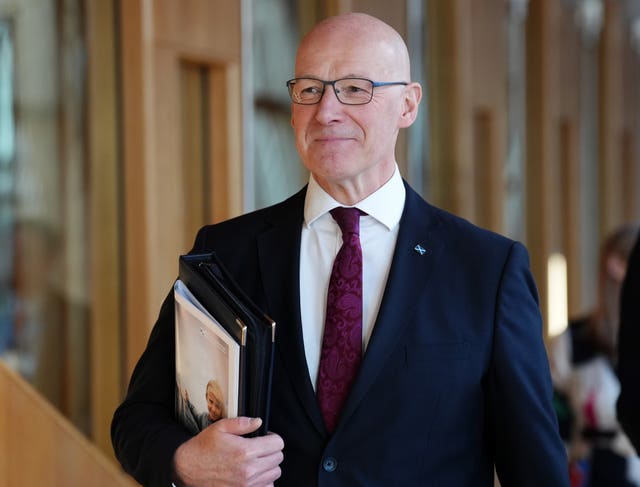 First Minister of Scotland John Swinney walking along a corridor